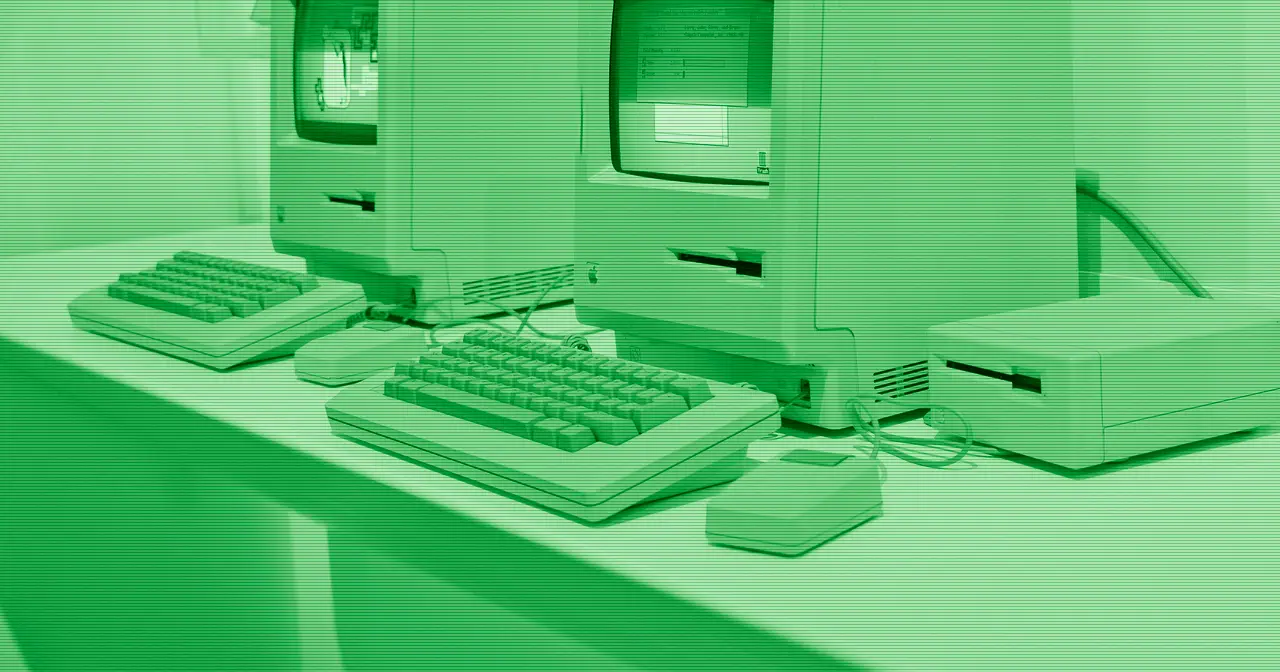 Ordenador antiguo de Apple sobre un escritorio en penumbra, evocando la herencia del Mac
