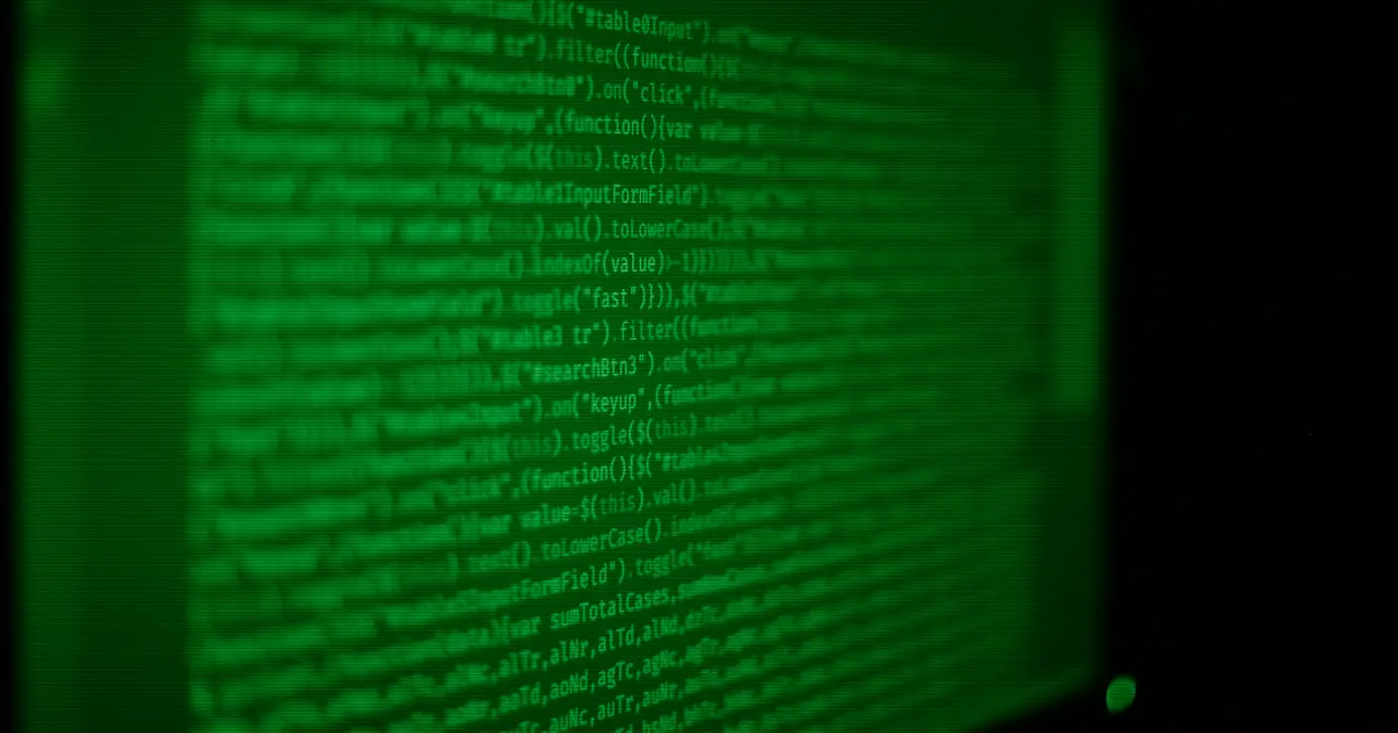 Pantalla con código y un terminal, símbolo del software libre que da origen a las distribuciones de Linux